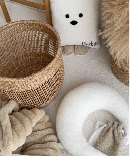 Dovanų rinkinys su baltais ir smėlio spalvos aksesuarais, įskaitant rankšluostį, krepšelį ir dekoro.