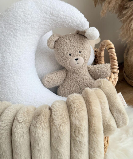 Plastikinis meškiukas su balta kepure ir minkšta pagalve.