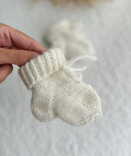 Mažas rankų darbo vaikiškas dovanų rinkinys su pilku megztu rūku.