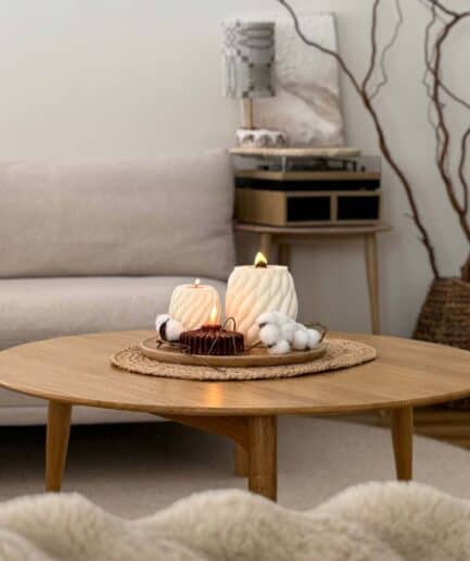 Žvakių rinkinys su dekoratyviniais elementais, kuriant jaukią atmosferą namuose.