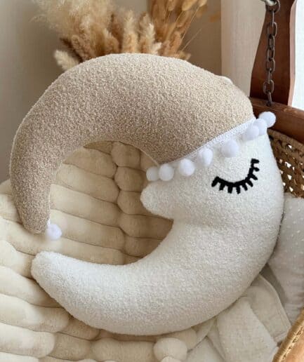 Dekoratyvinė mėnulio formos pagalvėlė su užrašu ir akimi.