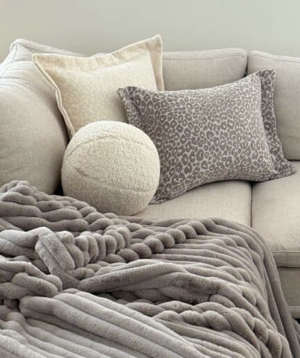 Aukštos kokybės pilkas dvipusis kailio pledas, puikiai tinka namų dekoro ir šilumos užtikrinimui.