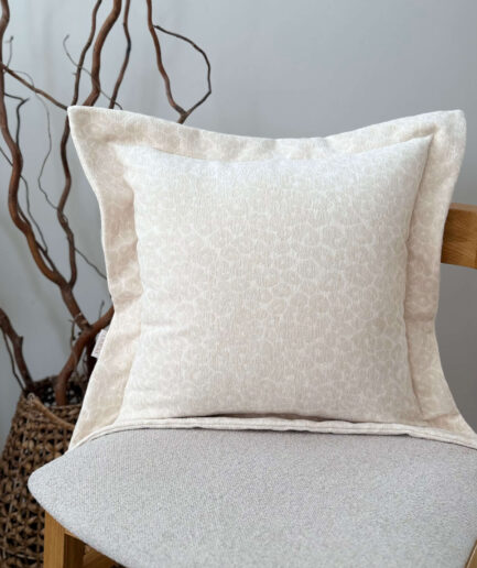 Elegantiška šviesiai kreminė dekoratyvinė pagalvėlė su subtiliu raštu.